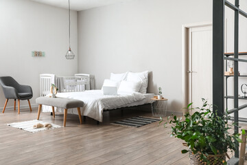 Fototapeta na wymiar Interior of light bedroom with white crib and armchair