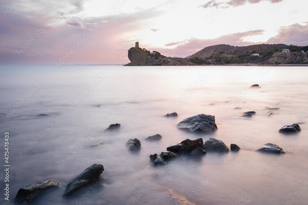 Sticker Scenic view of a rocky beach at sunset