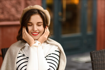 Happy woman with closed eyes wearing plaid outdoors