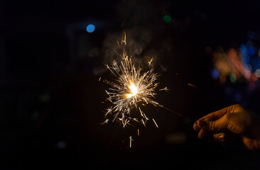 Sparkler or Fuljhadi in hand with dark black background to celebrate the festival of Diwali.