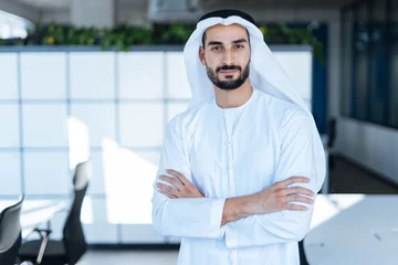 Foto op Plexiglas Handsome man with dish dasha working in his business office of Dubai. Portraits of a successful businessman in traditional emirates white dress. Concept about middle eastern cultures © oneinchpunch
