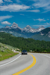 USA, Wyoming. Car on Ski Hill Road with view of Grand Teton, west side of Teton Mountains