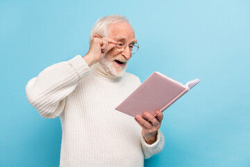 Photo of optimistic aged man read book wear spectacles pullover isolated on blue color background