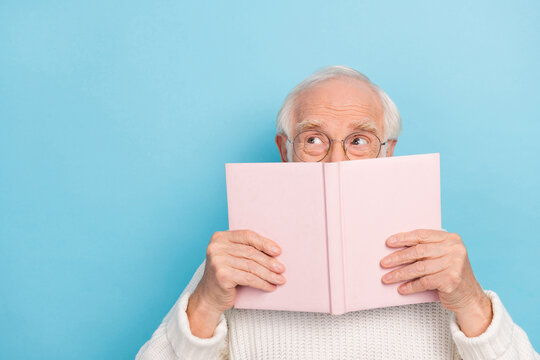 Photo of funny old man read book look empty space wear spectacles pullover isolated on blue color background