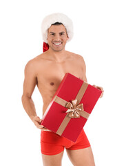 Sexy young man in Santa hat, underwear and with Christmas gift on white background