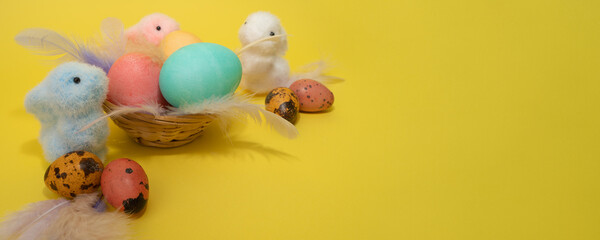 Fototapeta na wymiar Bunny toys and Easter eggs, feathers and nest. Happy easter concept. Copy space, banner