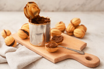 Tasty walnut shaped cookies with condensed milk on table