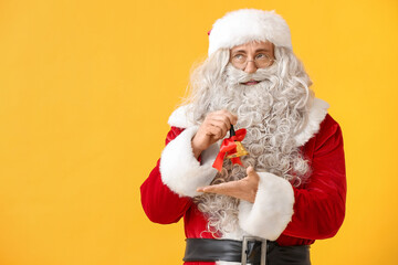 Santa Claus with Christmas bell on yellow background