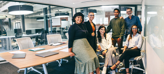 Team of businesspeople smiling at the camera in a boardroom - Powered by Adobe