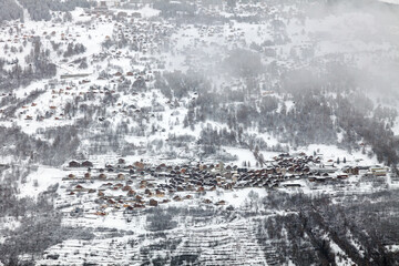 Fototapeta premium Village de montagne dans les nuages