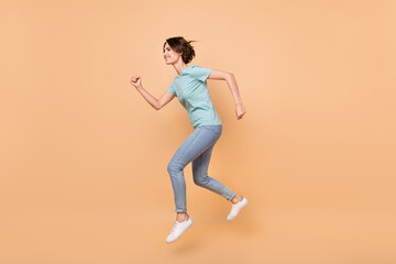 Full body profile side photo of young girl runner jumper look empty space hurry fast isolated over beige color background