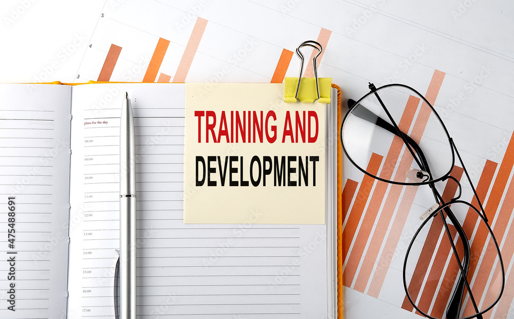 Aufkleber text training and development on sticker on the notepad on diagram background