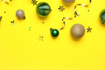 Beautiful Christmas balls and confetti on yellow background