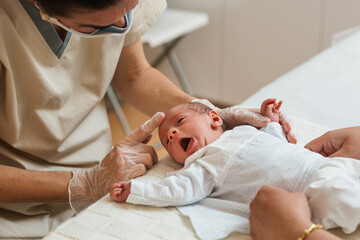 Physiotherapist evaluating the asymmetric tonic reflex in a newborn baby.
