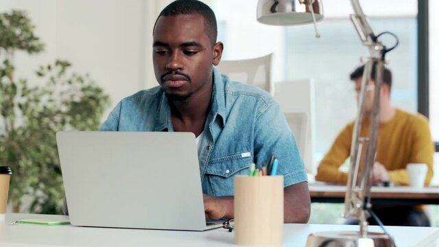 Video of two concentrated graphic designer working with computer in modern startup office.