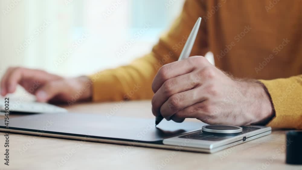 Poster video of close up of hands of graphic designer using a pen tablet while working with computer in mod