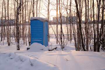 outdoor chemical toilet in the winter park . Eco-friendly bio toilet in nature. Blue Cabine Of Bio Toilet In the snow.
