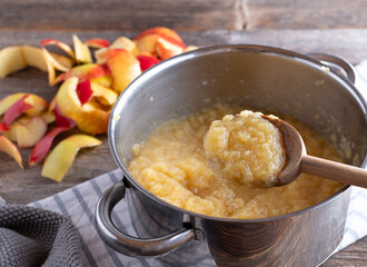 Homemade apple sauce in a pot with wooden spoon