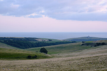 Farmland on South Downs, East Sussex with Belle Tout Lighthouse and the English Channel in the distance.