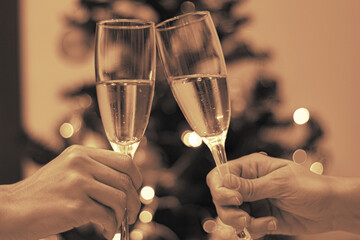 Two people making a toast during Christmas season in sepia tone