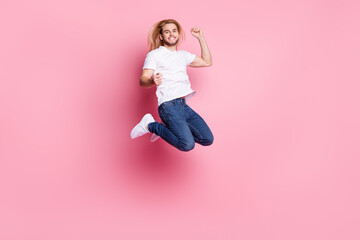 Full size photo of attractive young happy lady jump up winner triumph isolated on pastel pink color...