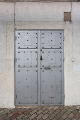 Old iron door reinforced with steel belts and rivets