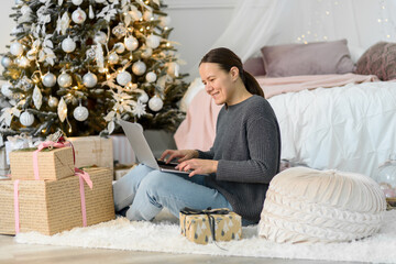 Woman with laptop, Christmas gifts and decorations. Buying or ordering online