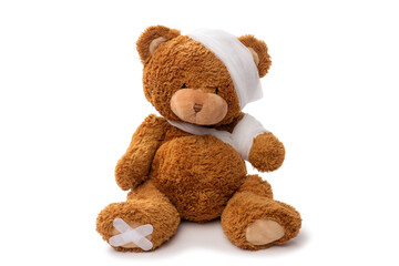 medicine, healthcare and childhood concept - teddy bear toy with bandaged head and paw on white background