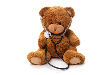 medicine, healthcare and childhood concept - teddy bear toy with stethoscope on white background