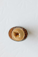 Top view of a glass jar of coffee without a lid, the gold-colored label is torn, the integrity of the packaging is broken, the background. Close-up.