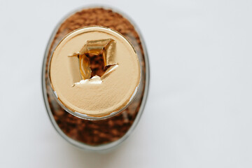 Top view of a glass jar of coffee without a lid, the gold-colored label is torn, the integrity of the packaging is broken, the background. Close-up.