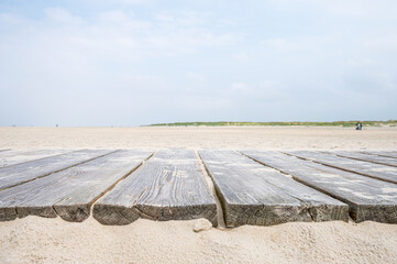 wooden planks on sandy beach as design element or design background