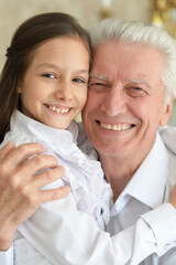 Happy elderly man with  cute granddaughter