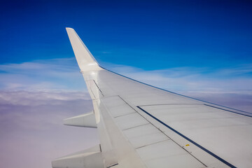 Fototapeta na wymiar Plane window view with blue sky and clouds.