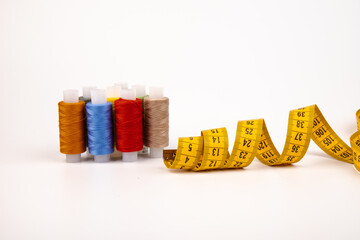 Sewing threads, sewing centimeter or measuring tape, isolated on white background.