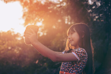 Young plant and girl. Little cute Girl give small plant to Sunshine.