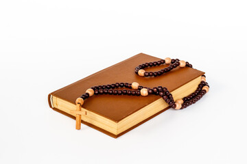 Rosary beads with cross on Bible book. Faith and prayer concept