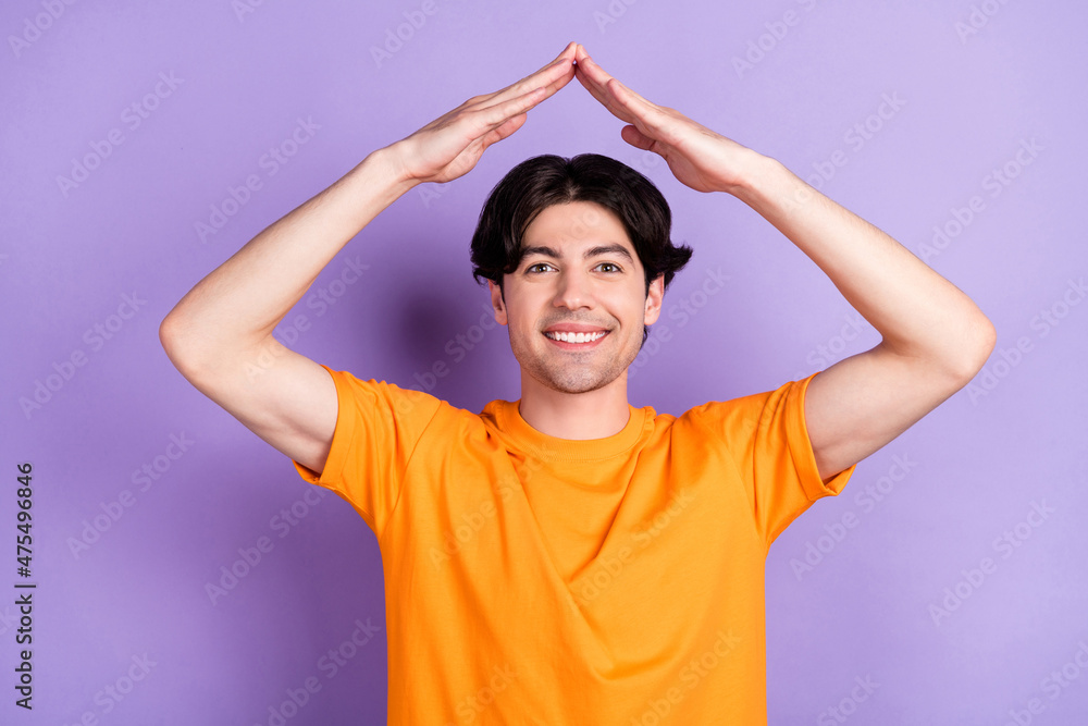 Sticker Photo of young charming happy positive man hold hands above head roof home isolated on violet color background