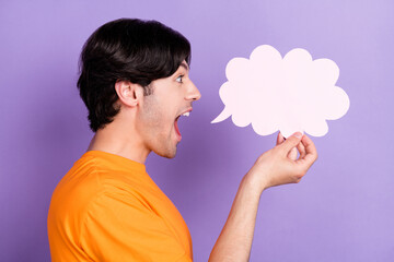 Profile side photo of happy positive young man hold hand cloud banner news isolated on purple color background