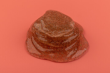 Coral transparent slime with bubbles inside on pink background. Kids toy slime.