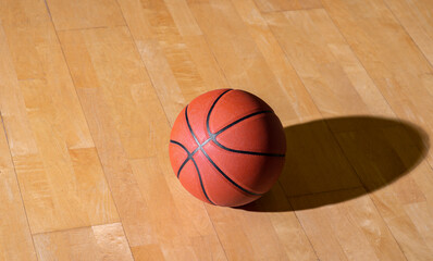 Basketball on hardwood court floor with lighting. Workout online concept. Horizontal sport theme poster, greeting cards, headers, website and app