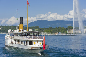famous water jet and a vintage steamboat cruising on Lake Geneva, Geneva, Switzerland

