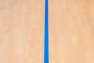 Wooden floor  basketball, badminton, futsal, handball, volleyball, football, soccer court. Wooden floor of sports hall with marking blue lines on wooden floor indoor, gym court