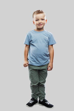 The boy is 5 years old. A child in jeans and a blue T-shirt. Isolated on a light gray background. Full height. Vertical.