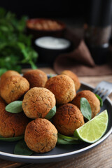Delicious falafel balls with lime on table, closeup