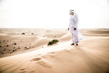 Cinematic storytelling image of a man spending time in the desert. Middle aged person wearing...