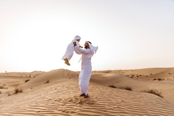 Father and son spending time in the desert on a safari day. Arabian family from the emirates...