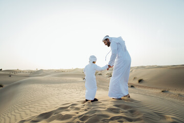 Father and son spending time in the desert on a safari day. Arabian family from the emirates...