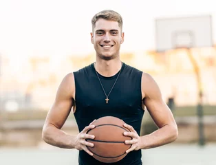 Gardinen Caucasian athletic man holding a basketball outdoors © Samuel Perales