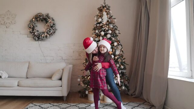  mom little daughter fooling around embrace at home enjoy Christmas holidays